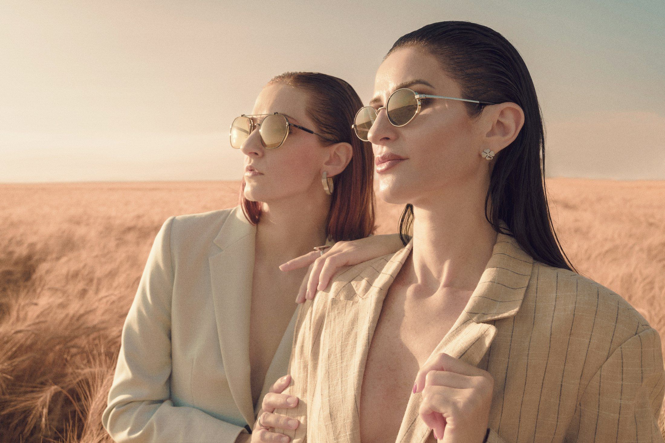 Duas mulheres de óculos de sol em um campo dourado