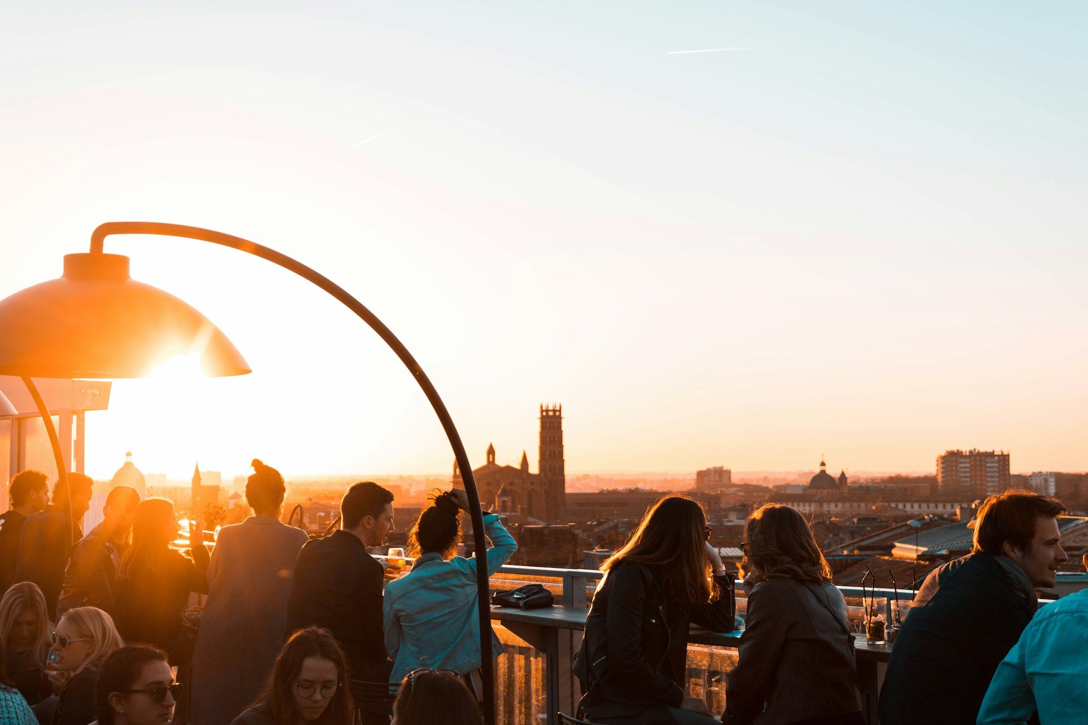 Terraço com pessoas ao pôr do sol